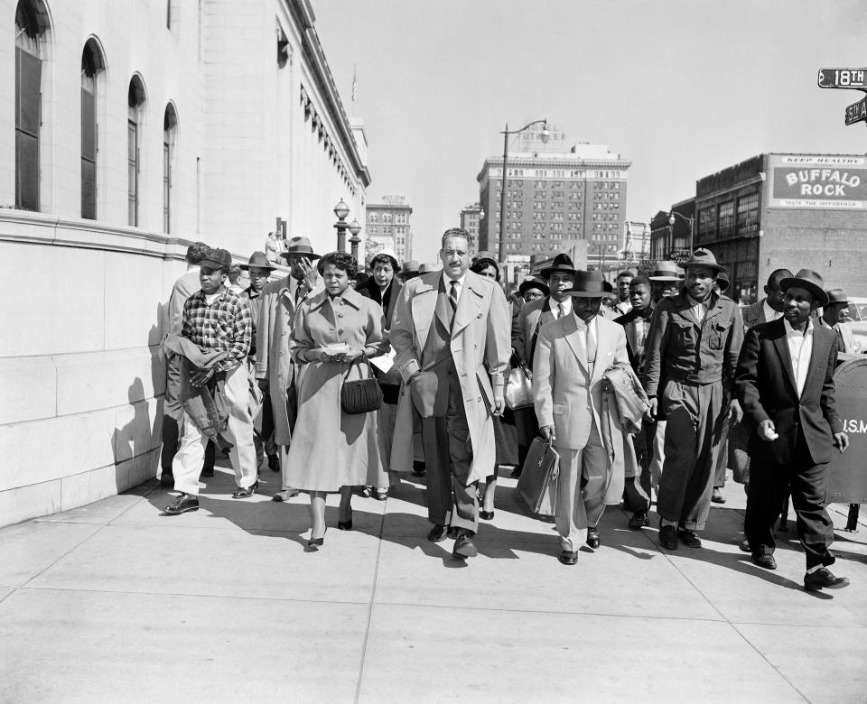 Autherine Lucy, left, front, 26-year-old student at the University of Alabama, arrives at U.S. District Court for the hearing of her petition for an order requiring the school to re-admit her to classes in Birmingham, Ala., Feb. 29, 1956. With Lucy are her legal team, Thurgood Marshall, tall man at center, and Arthur Shores, carrying coat at right. Gene Herrick, a retired Associated Press photographer who covered the Korean War and is known for his iconic images of Martin Luther King Jr., Rosa Parks and the civil rights movement, died Friday, April 12, 2024 at a nursing home in Rich Creek, Virginia. He was 97. (AP Photo/Gene Herrick)