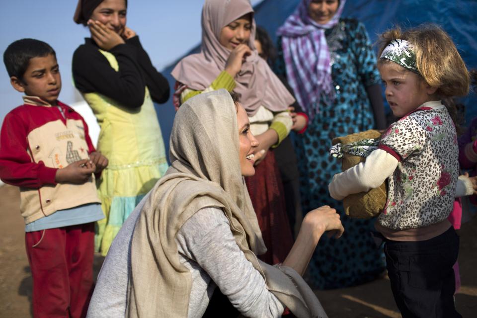 In this Sunday February 23, 2014 photo released by the United Nations High Commission for Refugees, actress and U.N. special envoy Angelina Jolie, center foreground, meets with young Syrian refugees at an informal tented settlement in Zahleh, Bekaa Valley, Lebanon. Jolie made a surprise visit to Lebanon to draw attention to the challenges facing thousands of Syrian refugee children and to highlight the massive displacement Syria’s three-year conflict has created, officials said Monday. (AP Photo/UNHCR/A. McConnell)