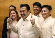 Manila Mayor Joseph Estrada, center, gestures during a news conference in Hong Kong Wednesday, April 23, 2014. Hong Kong and the Philippines reached a compromise Wednesday over Hong Kong's demands for an apology for the families of eight tourists killed in a bungled response to a 2010 Manila hostage-taking that soured relations. (AP Photo/Kin Cheung)