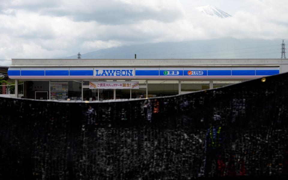 A black shading net is installed on the opposite side of the Lawson Kawaguchiko Ekimae convenience store