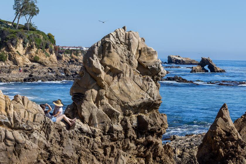 Newport Beach, CA - March 19: Beach-goers enjoy the view from the rocks on the first day of spring with clear skies and warm weather at Little Corona del Mar Beach in Newport Beach Tuesday, March 19, 2024. (Allen J. Schaben / Los Angeles Times)