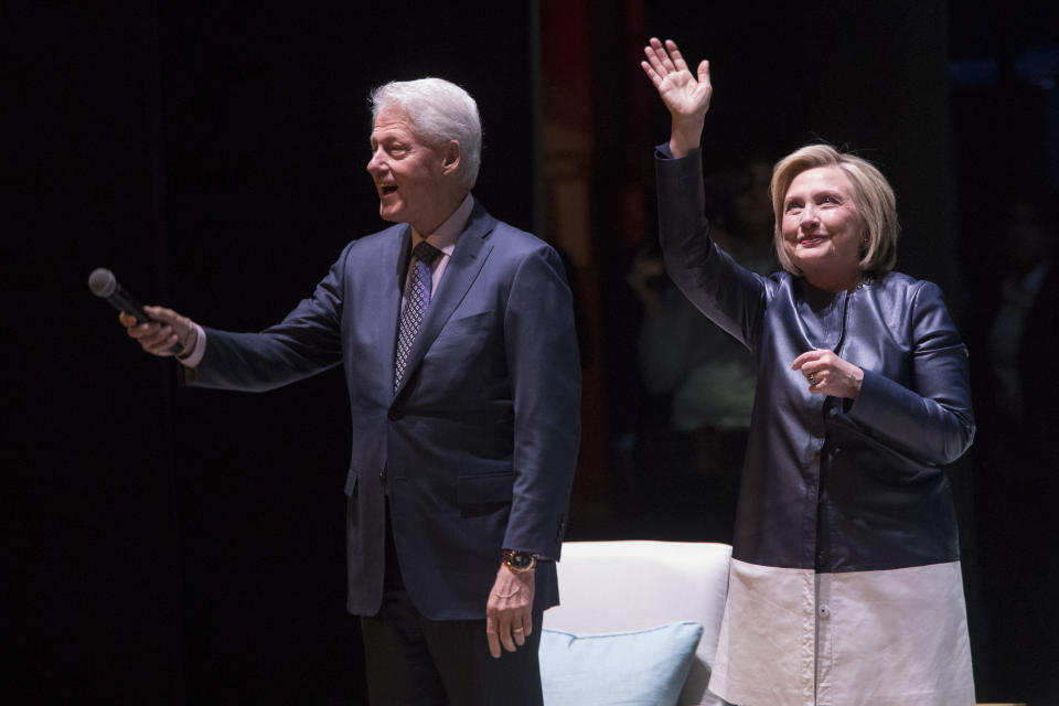 Former President Bill Clinton, left, and former Secretary of State Hillary Rodham Clinton wave at the crowd as they arrive on stage for "An Evening with the Clintons," at the Beacon Theatre Thursday, April 11, 2019, in New York. (AP Photo/Mary Altaffer)