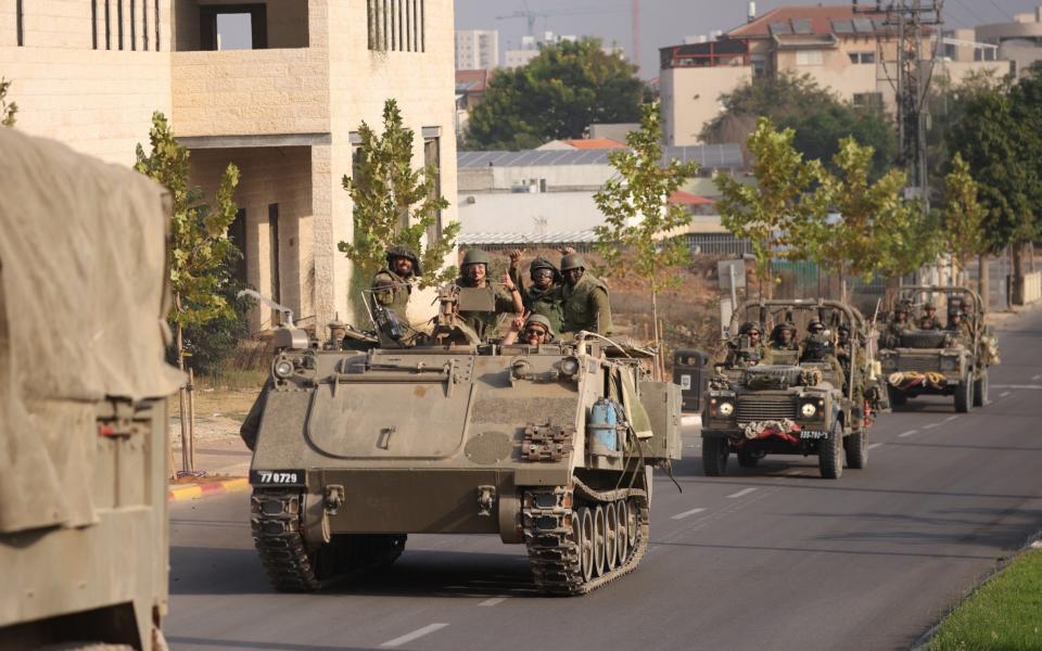 Israeli tanks and troops move near the border with Gaza on Saturday