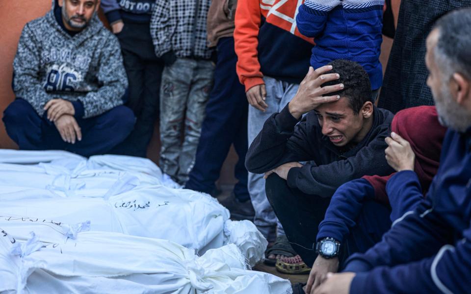 A young relative mourns over the bodies of families at the morgue of the Nasser medical centre in Khan Younis