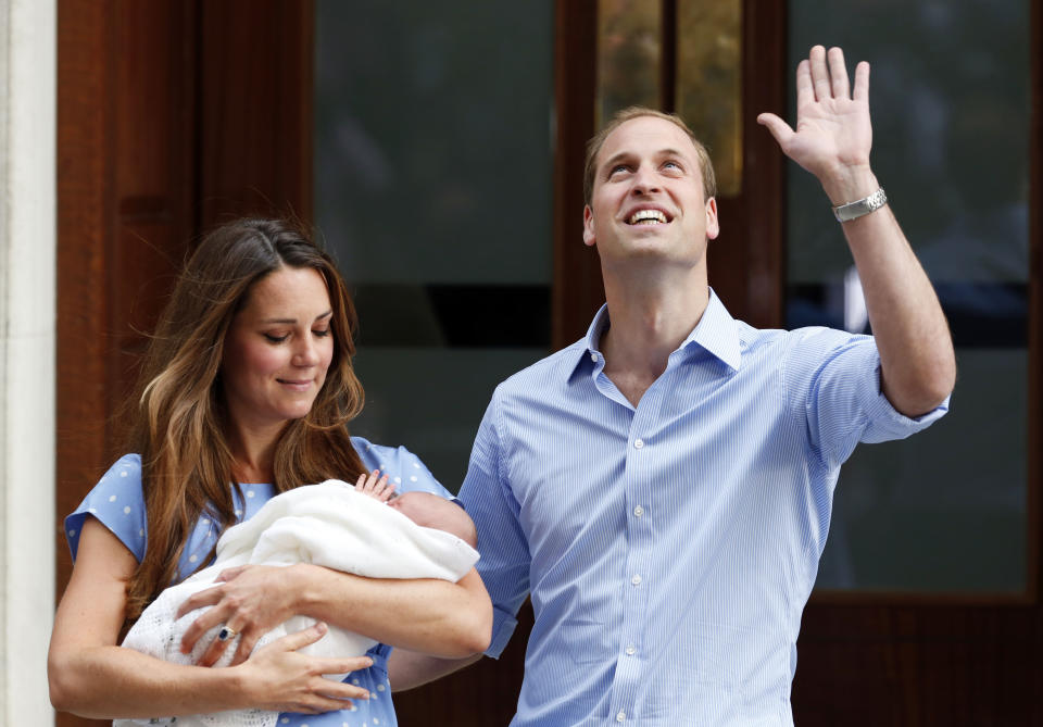 FILE - Britain's Prince William and Kate, Duchess of Cambridge holding their son, Tuesday July 23, 2013, as they pose for photographers outside St. Mary's Hospital exclusive Lindo Wing in London. The world watched as Prince William grew from a towheaded schoolboy to a dashing air-sea rescue pilot to a father of three. But as he turns 40 on Tuesday, June 21, 2022, William is making the biggest change yet: assuming an increasingly central role in the royal family as he prepares for his eventual accession to the throne. (AP Photo/Lefteris Pitarakis, File)