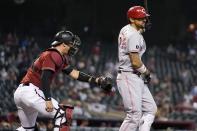 Arizona Diamondbacks catcher Carson Kelly, left, tags out Cincinnati Reds' Nick Castellanos, right, after a dropped third strike during the first inning of a baseball game Sunday, April 11, 2021, in Phoenix. (AP Photo/Ross D. Franklin)