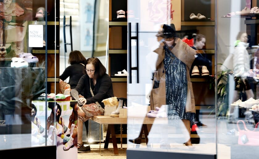 LOS ANGELES-CA-MARCH 4, 2022: Shoppers try on shoes at Westfield Century City in Los Angeles on Friday, March 4, 2022. Los Angeles County ends indoor mask mandates today. (Christina House / Los Angeles Times)