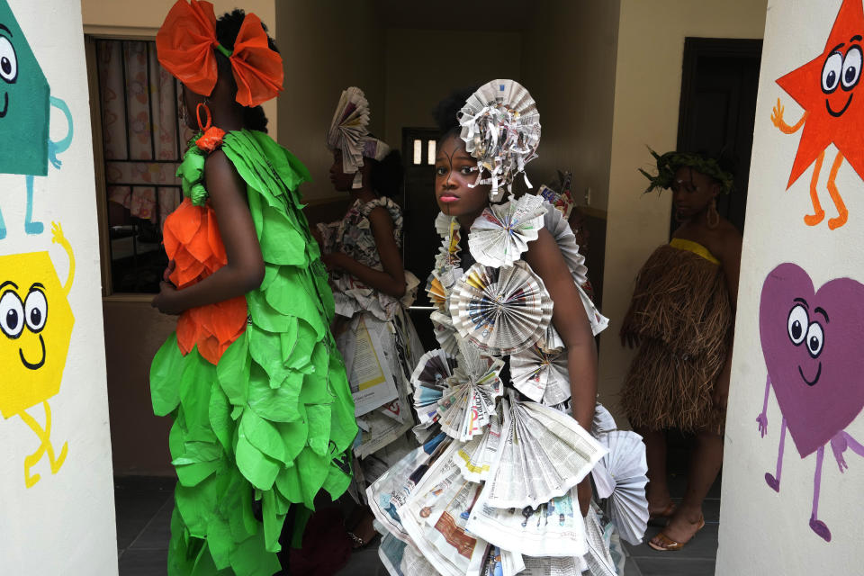 Jalokun Nifemi, wearing an outfit made from recycled newspapers, waits back stage before a 'trashion show' in Sangotedo Lagos, Nigeria, Saturday, Nov. 19, 2022. (AP Photo/Sunday Alamba)