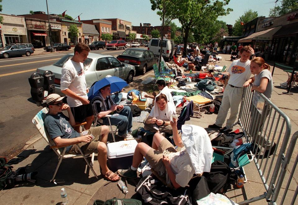 People camped outside a movie theater in daylight