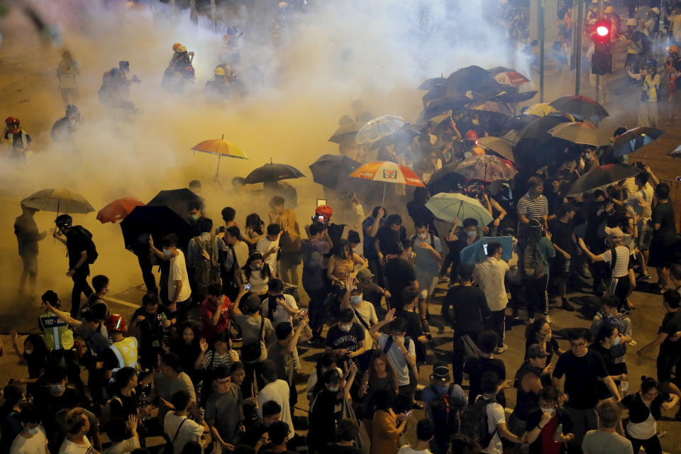 Police fire tear gas into a crowd in Wong Tai Sin district in Hong Kong on Saturday, Aug. 3, 2019. Protesters and authorities clashed in Hong Kong again on Saturday, as demonstrators removed a Chinese national flag from its pole and flung it into the city's iconic Victoria Harbour and police fired tear gas after some protesters vandalized a police station. (AP Photo/Kin Cheung)