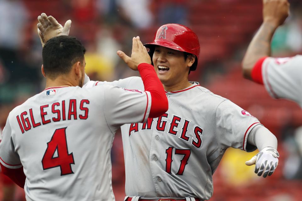 Los Angeles Angels' Shohei Ohtani (17) celebrates his two-run home run with teammate Jose Iglesias (4) during the ninth inning of a baseball game against the Boston Red Sox, Sunday, May 16, 2021, in Boston. (AP Photo/Michael Dwyer)