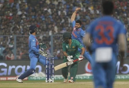 Cricket - India v Pakistan- World Twenty20 cricket tournament - Kolkata, India, 19/03/2016. India's Suresh Raina (2nd R) jumps to field the ball off the bat of Pakistan's Ahmed Shehzad as India's captain and wicketkeeper Mahendra Singh Dhoni (L) looks on. REUTERS/Rupak De Chowdhuri