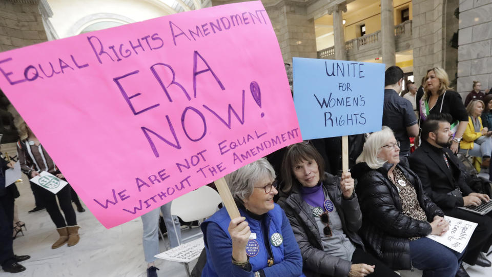 This Tuesday, Dec. 3, 2019, photo, Equal Rights Amendment supporters Donnie Davis, left, and Jeanne Mackenzie, join others during a rally at the Utah State Capitol, in Salt Lake City. Roughly 200 people gathered at the Capitol to encourage Utah to ratify the Equal Rights Amendment. The renewed national push to ratify the Equal Rights Amendment is coming to conservative Utah, where supporters are launching a long-shot bid to challenge Virginia in becoming a potential tipping point despite opposition from the influential Church of Jesus Christ of Latter-day Saints. (AP Photo/Rick Bowmer)