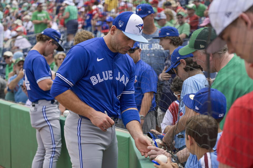 Toronto Blue Jays' Joey Votto, center, signs autographs before a spring training baseball game against the Philadelphia Phillies Sunday, March 17, 2024, in Clearwater, Fla. (Steve Nesius/The Canadian Press via AP)