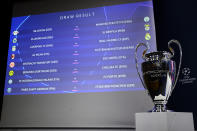 The match fixtures are shown on an electronic panel next to the Champions League trophy during the UEFA Champions League 2022/23 round of 16 draw, at the UEFA Headquarters in Nyon, Switzerland, Monday, Nov. 7, 2022.(Laurent Gillieron/Keystone via AP)