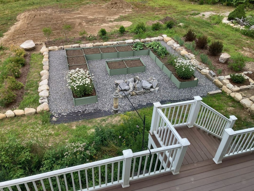 a deck with a stone wall and a garden