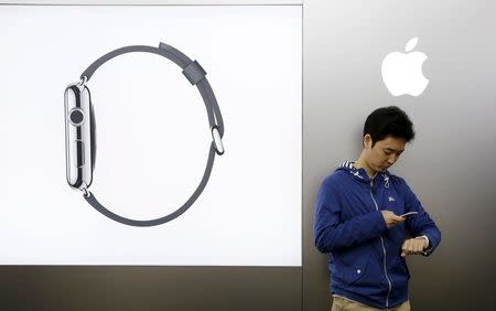 Customer Tomoyoshi Fujimura sets up his Apple Watch, which is to be paired with his iPhone, after buying it at an electronics store in Tokyo April 24, 2015. REUTERS/Toru Hanai