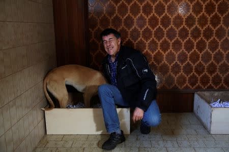 David Villanueva, 44, reacts as he caresses Atila, a trained therapeutic greyhound used to treat patients with mental health issues and learning difficulties, in its bed at Benito Menni health facility in Elizondo, northern Spain, February 13, 2017. REUTERS/Susana Vera