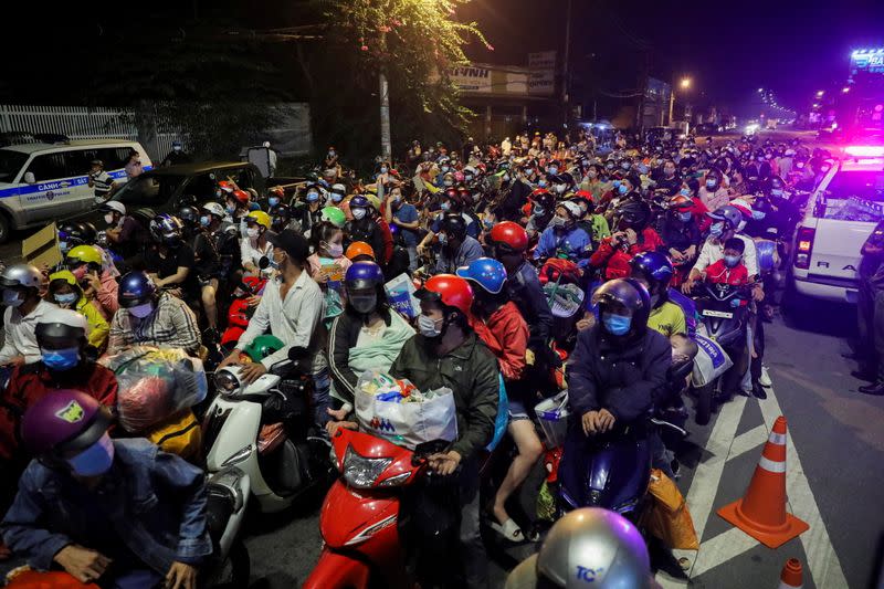 People planning to return to their hometowns wait at a checkpoint to leave Ho Chi Minh