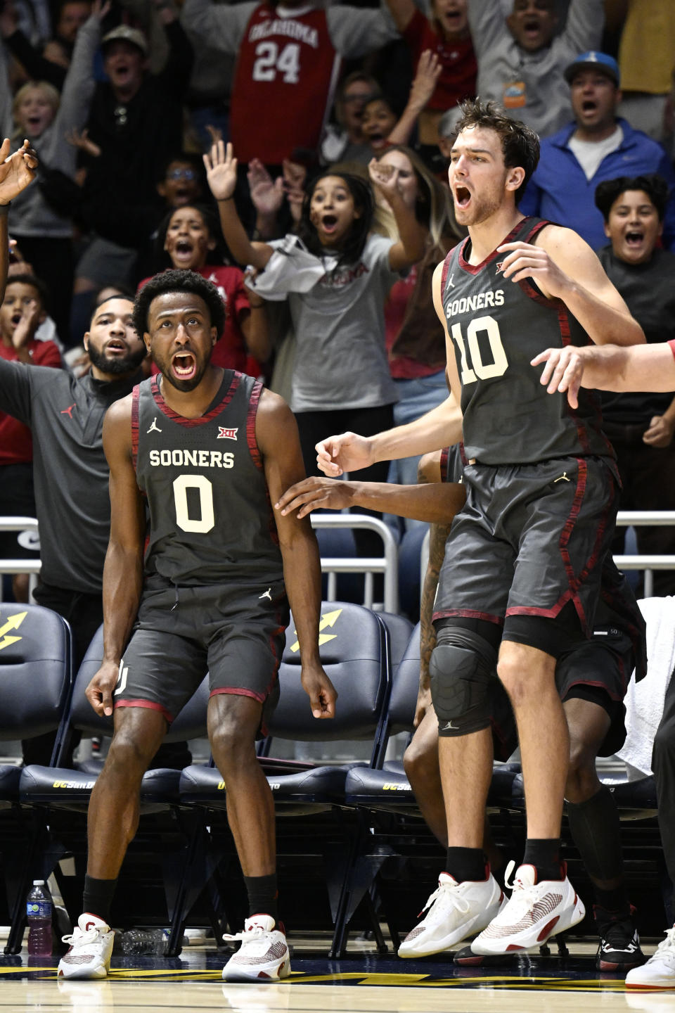 Oklahoma guard Le'Tre Darthard (0) and forward Sam Godwin (10) celebrate during the second half of the team's NCAA college basketball game against Southern California on Friday, Nov. 24, 2023, in San Diego. (AP Photo/Denis Poroy)