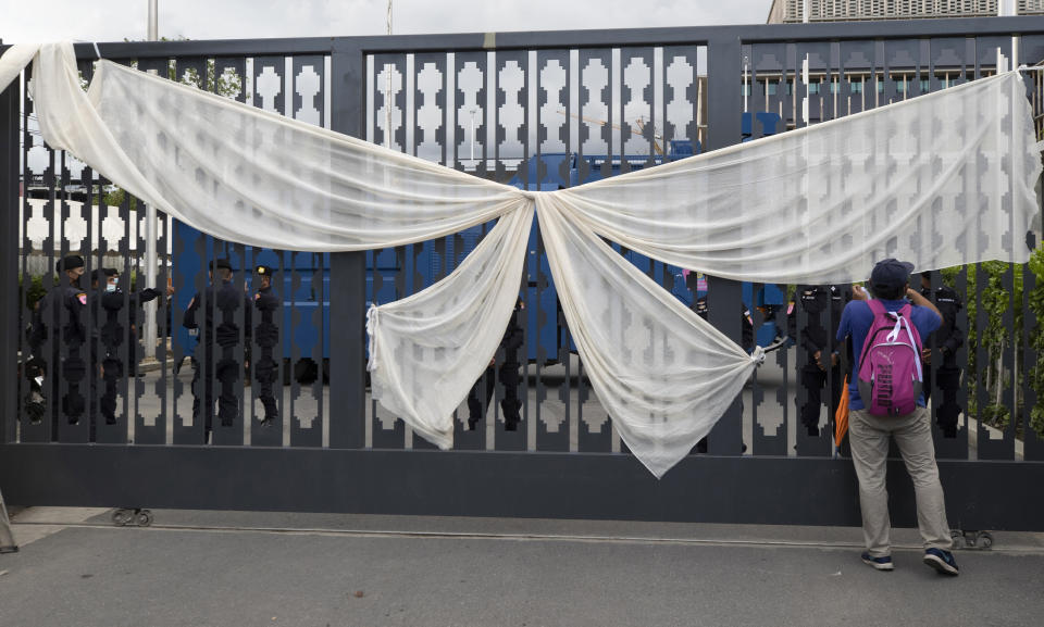 A pro-democracy demonstrator hangs a giant white ribbon dismissing the government during a protest outside the Parliament in Bangkok, Thailand, Thursday, Sept. 24, 2020. Lawmakers in Thailand are expected to vote Thursday on six proposed amendments to the constitution, as protesters supporting pro-democratic charter reforms gathered outside the parliament building. (AP Photo/Sakchai Lalit)