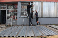 <p>Men cover the windows of a car parts store in preparation for Hurricane Irma in San Juan, Puerto Rico, Sept. 5, 2017. (Photo: Alvin Baez/Reuters) </p>