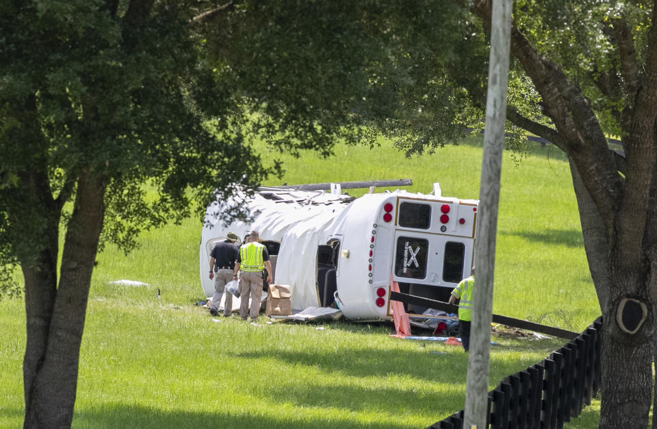 Policía y socorristas inspeccionan un autobús que se volcó tras chocar con una camioneta matando a ocho de 50 jornaleros que iban en el camión, el 14 de mayo de 2024, en Ocala, Florida. (Foto AP/Alan Youngblood)