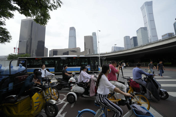 Commuters past through the Central Business District during rush hour in Beijing on Friday, July 2, 2021. A small but visible handful of urban Chinese are rattling the ruling Communist Party by choosing to "lie flat," or reject high-status careers, long work hours and expensive cities for a "low-desire life." That clashes with party ambitions to make China a wealthier consumer society. (AP Photo/Ng Han Guan)