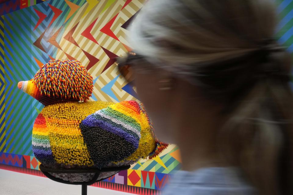 Visitors look at sculptures on display inside the US pavilion by artist Jeffrey Gibson during the 60th Biennale of Arts in Venice, Italy, Tuesday, April 16, 2024. A Mississippi Choctaw of Cherokee descent, Gibson is the first Native American to represent the United States solo at the Venice Biennale, the world’s oldest contemporary art show. Gibson mixes Western modernism and Native American craft in his vibrantly hued paintings and sculptures. (AP Photo/Luca Bruno)