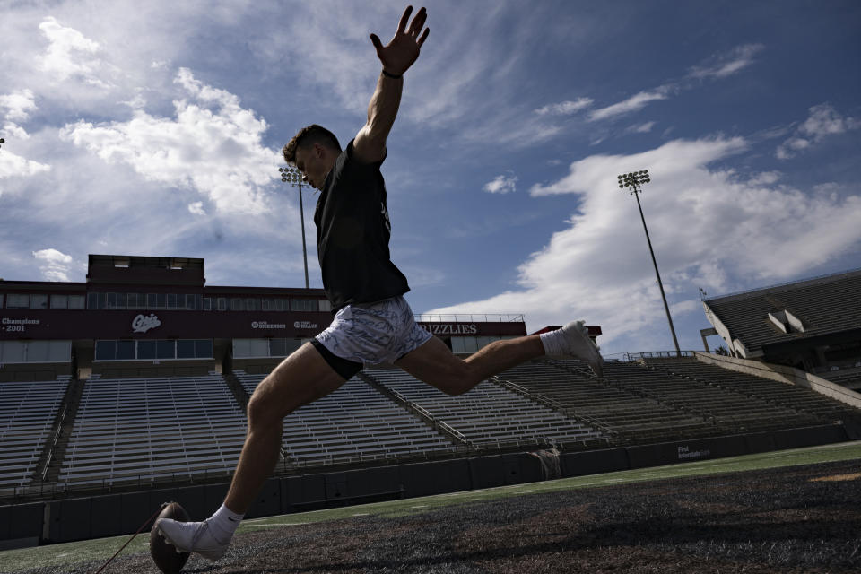 Adam Botkin, a football TikTok influencer, kicks at Washington-Grizzly Stadium in Missoula, Mont., on Monday, May 1, 2023. Botkin, a former walk-on place kicker and punter for the Montana Grizzlies, gained notoriety on the social media platform after videos of him performing kicking tricks went viral. (AP Photo/Tommy Martino)