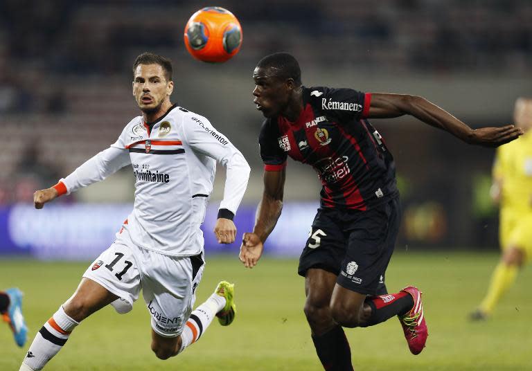 Nice defender Romain Genevois heads the ball past Lorient's Jeremie Aliadiere during their French L1 match on April 12, 2014 at the "Allianz Riviera" stadium