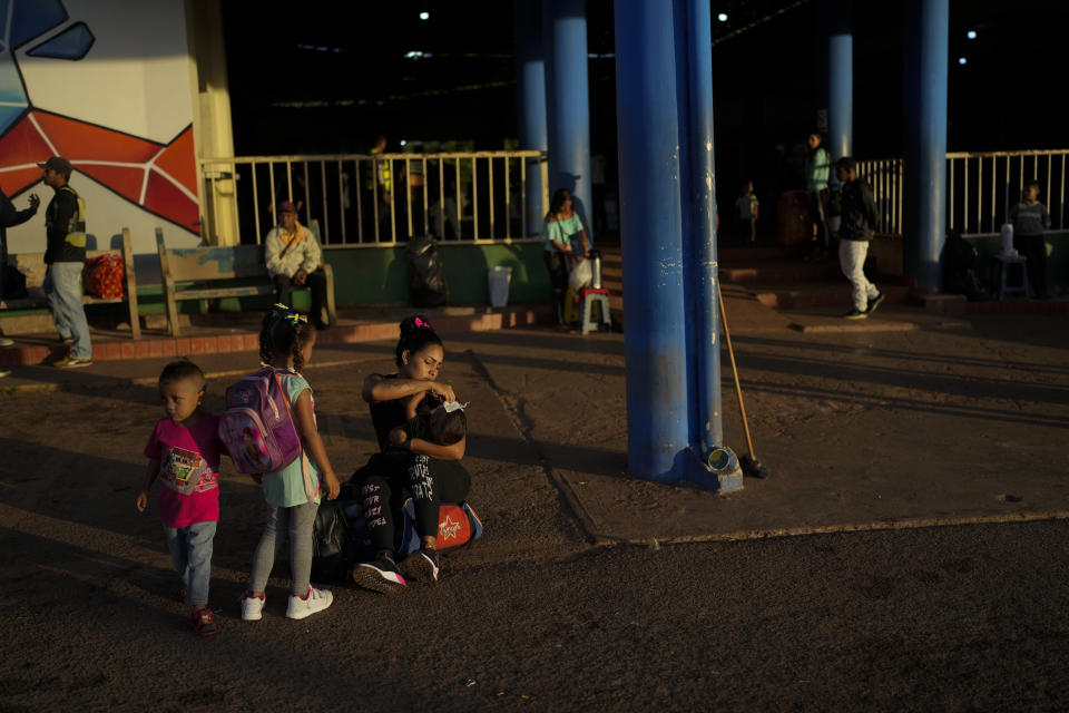 Venezuelan migrant Maryelis Rodriguez and three of her four children wait for a transportation that will take them to the Brazilian border, in Santa Elena de Uairen, Venezuela, Wednesday, April 5, 2023. Rodriguez and her partner Miguel Gonzalez left San Felix with their four children and $500 dollars. (AP Photo/Matias Delacroix)