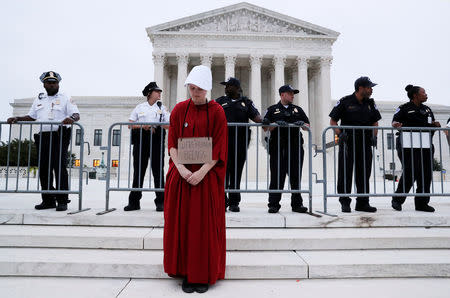 A protester stands on the steps of the U.S. Supreme Court building in front of police after they cleared the steps of demonstrators while Judge Brett Kavanaugh was being sworn in as an Associate Justice of the court inside on Capitol Hill in Washington, U.S., October 6, 2018. REUTERS/Jonathan Ernst