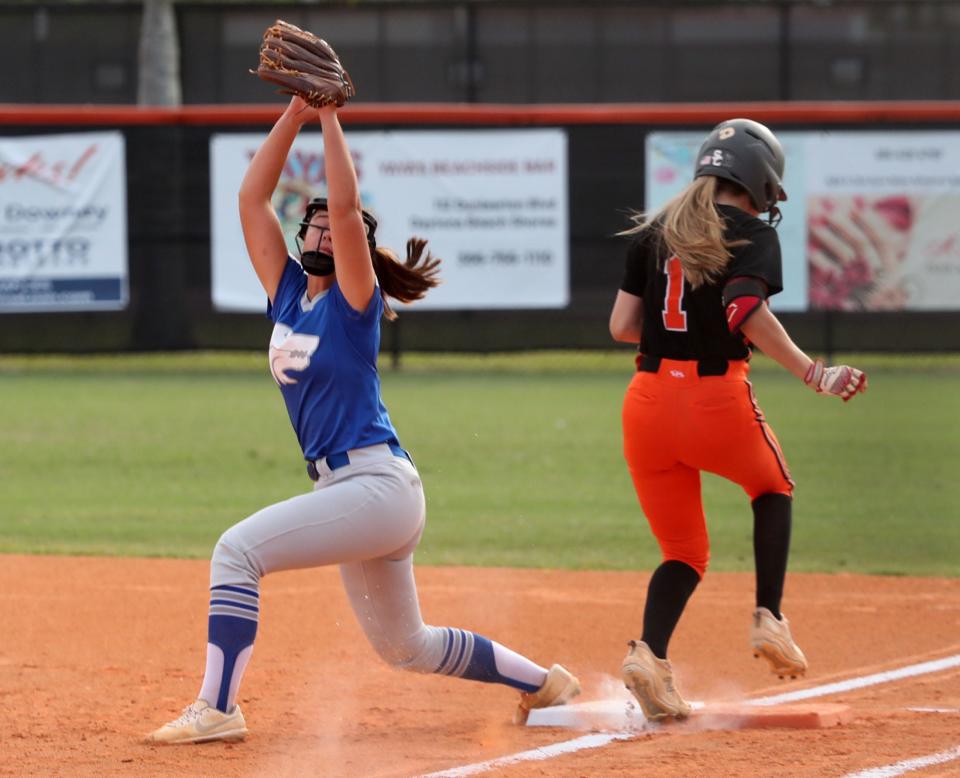 Deltona's Kaitlyn Sarvis streatches high for the catch get to Spruce Creek's Neena Hernandez at first, Wednesday April 20, 2022.