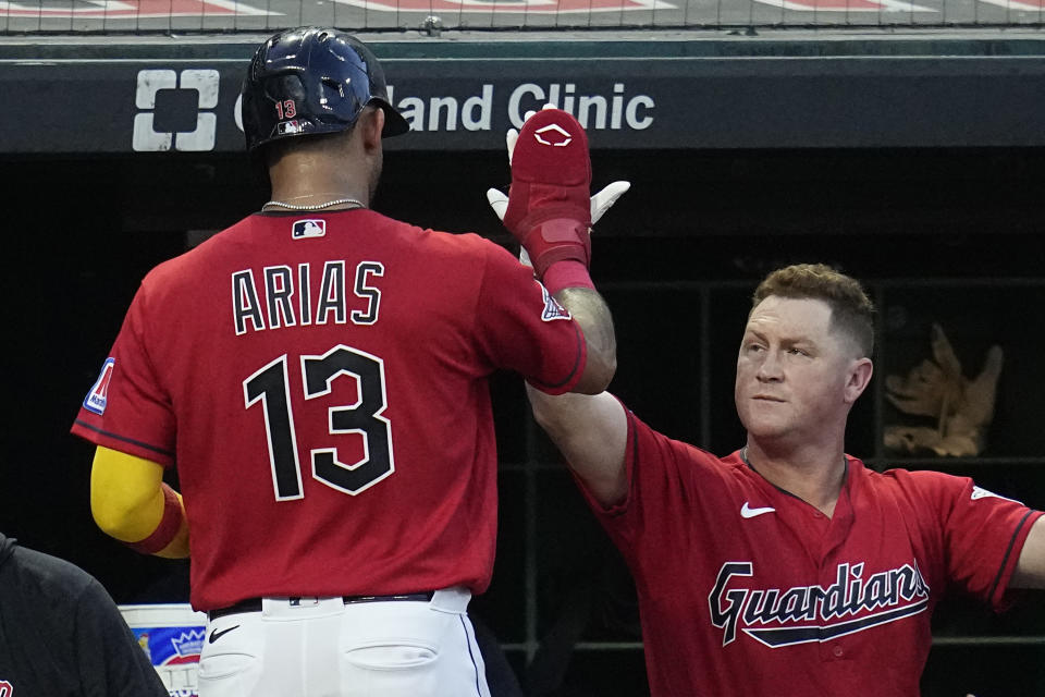 Cleveland Guardians' Gabriel Arias (13) gets a high five from teammate Kole Calhoun after scoring in the fifth inning of a baseball game against the Minnesota Twins, Tuesday, Sept. 5, 2023, in Cleveland. (AP Photo/Sue Ogrocki)