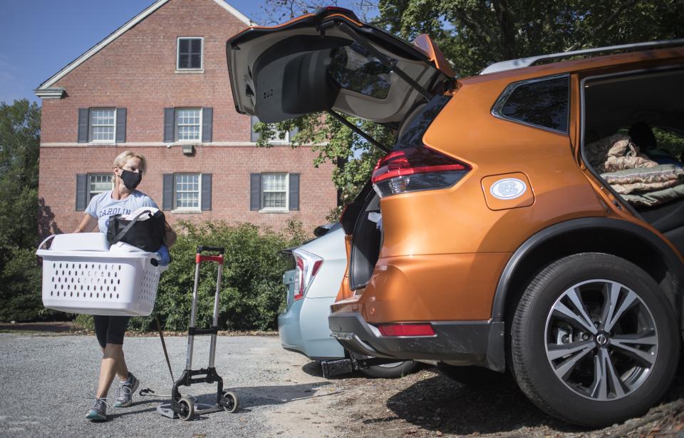 FILE - Darlene Genander loads up her vehicle as she helps junior UNC-Chapel Hill student Caitlin Sockin move out of Alderman Residence Hall in Chapel Hill, N.C. on Wednesday, Aug. 19, 2020. As more universities keep classes online this fall, it’s leading to conflict between students who say they deserve tuition discounts and college leaders who insist remote learning is worth the full cost. (Julia Wall/The News & Observer via AP, File)