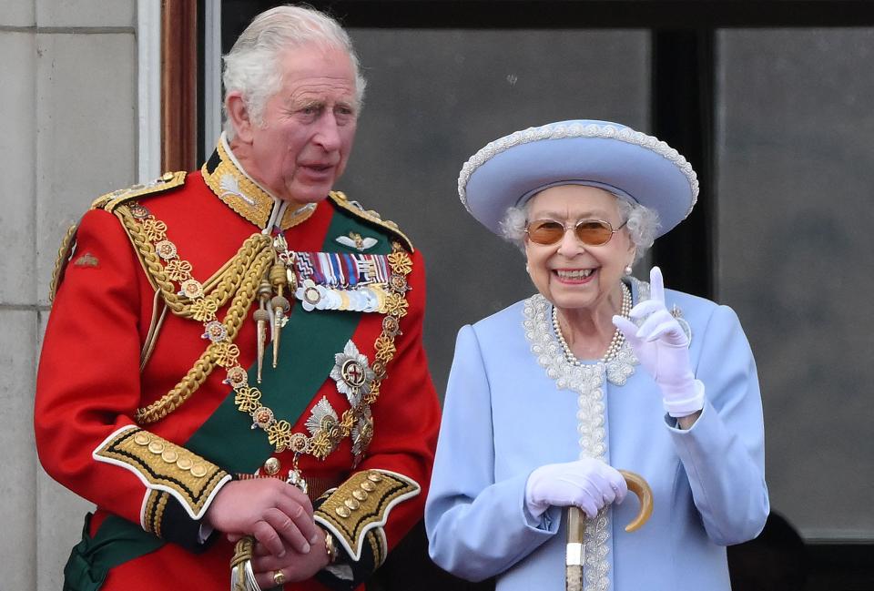 Queen Elizabeth II, right, stands with Prince Charles to watch a special flypast from Buckingham Palace balcony following the queen's birthday parade, the Trooping the Colour, as part of Queen Elizabeth II's platinum jubilee celebrations, in London on June 2, 2022.
