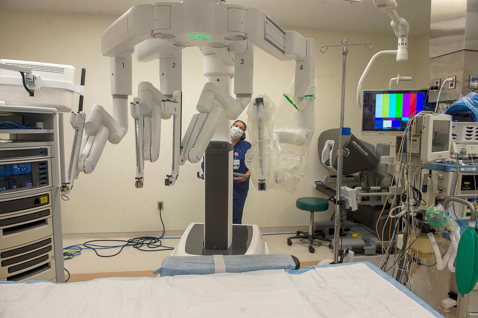 In an operating room at Milford Regional Medical Center, operating room registered nurse Jessica Barth moves the da Vinci Xi robot assisted surgery system into place, Aug. 9, 2022.