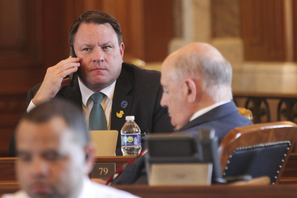 Kansas state Rep. Jesse Borjon, R-Topeka, speaks on his phone at his desk in the House chamber during a break in the House's daylong session, Monday, April 29, 2024, at the Statehouse in Topeka, Kan. Borjon has switched from voting for a proposed ban on gender-affirming care for minors to voting against overriding Democratic Gov. Laura Kelly's veto of the measure. (AP Photo/John Hanna)