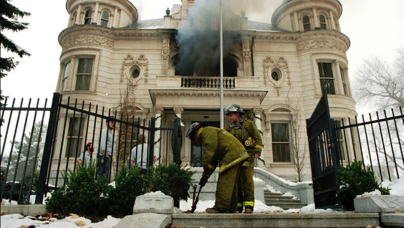 Firefighters use bolt cutters to open the front gates as smoke pours from the second floor of the Governor’s Mansion in Salt Lake City Dec. 15, 1993. 