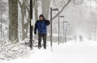 Marius Daugirdas skis on the sidewalk on Saturday, Dec. 14, 2013., in Evanston, Ill. Snow continued to fall over the Chicago area into northwest Indiana. (AP Photo/Nam Y. Huh)