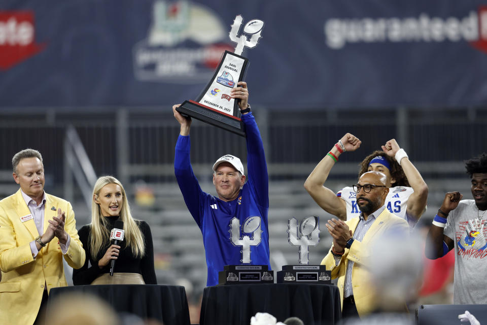 PHOENIX, ARIZONA - DECEMBER 26: Head coach Lance Leipold of the Kansas Jayhawks lifts the championship trophy after the Jayhawks defeated the UNLV Rebels 49-36 in the Guaranteed Rate Bowl at Chase Field on December 26, 2023 in Phoenix, Arizona. (Photo by Chris Coduto/Getty Images)