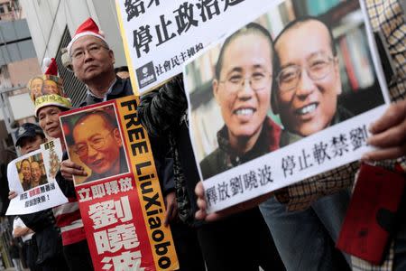 FILE PHOTO: Pro-democracy demonstrators hold up photo of jailed Chinese Nobel Peace Prize laureate Liu Xiaobo during a protest to urge for the release of Liu, who was sentenced to imprisonment seven years ago on Christmas day, outside the Chinese liaison office in Hong Kong, China December 25, 2016. REUTERS/Tyrone Siu