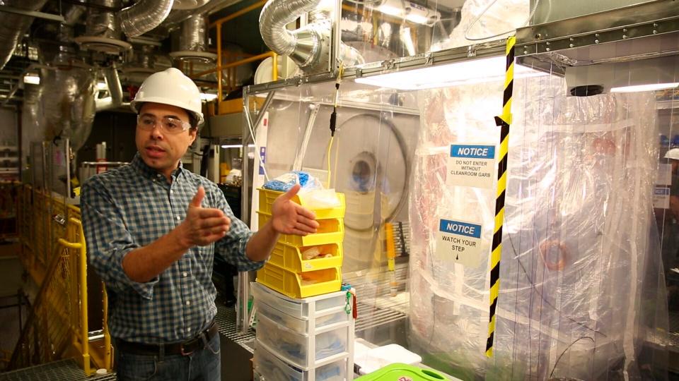 Aaron Manalaysay, the physics coordinator of Lawrence Berkeley National Lab's experiment, explains how the underground detector will interact with dark matter in the Sanford Underground Research Facility in Lead, S.D., on Dec. 8, 2019.  Scientists have begun a new search for mysterious dark matter in a former gold mine a mile underground. Dark matter makes up the vast majority of the mass of the universe but scientists don't know what it is. (AP Photo/Stephen Groves)