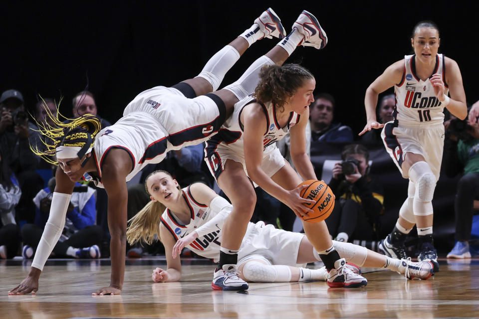 UConn forward Aaliyah Edwards, left, dives over UConn guard Ashlynn Shade during the first half of the team's Sweet 16 college basketball game against Duke in the women's NCAA Tournament, Saturday, March 30, 2024, in Portland, Ore. (AP Photo/Howard Lao)