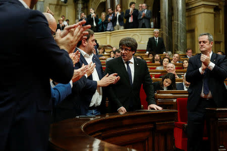 Catalan President Carles Puigdemont (C) is applauded after delivering a speech in the Catalonian regional parliament in Barcelona, Spain, October 10, 2017. REUTERS/Albert Gea