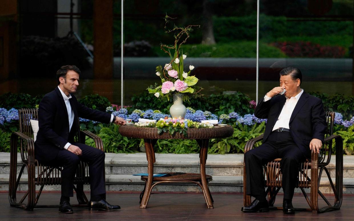 Chinese President Xi Jinping (R) and French President Emmanuel Macron attend a tea ceremony at the Guandong province governor's residence in Guangzhou on April 7, 2023 - THIBAULT CAMUS/AFP