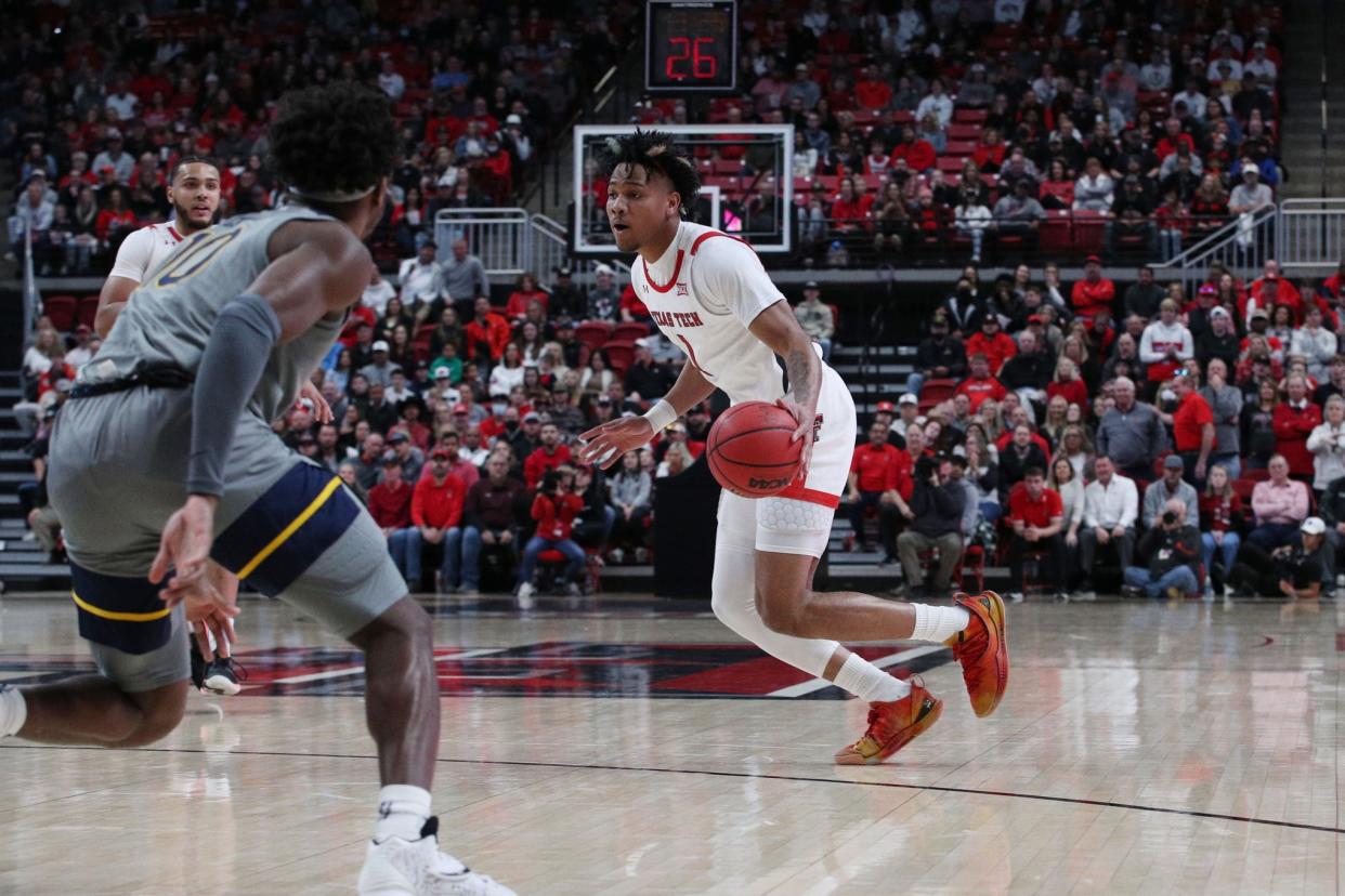 Texas Tech's Terrence Shannon, Jr. (1) drives the ball against West Virginia's Malik Curry (10) during the first half of a Big 12 Conference game Saturday at United Supermarkets Arena. Shannon finished with a season-best 23 points.