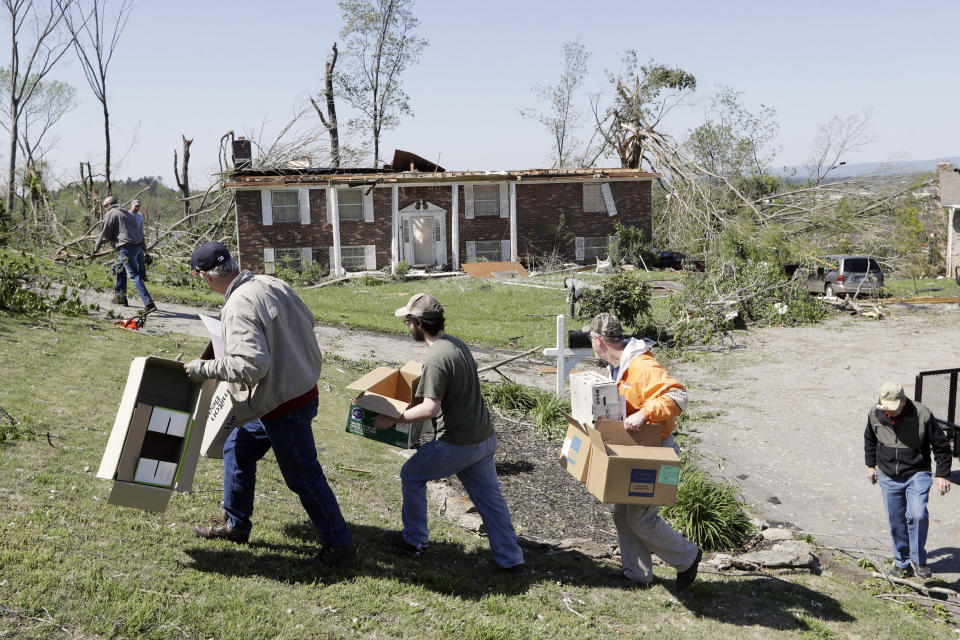 Workers carry boxes to a storm-damaged home Tuesday, April 14, 2020, in Chattanooga, Tenn. Tornadoes went through the area Sunday, April 12. (AP Photo/Mark Humphrey)