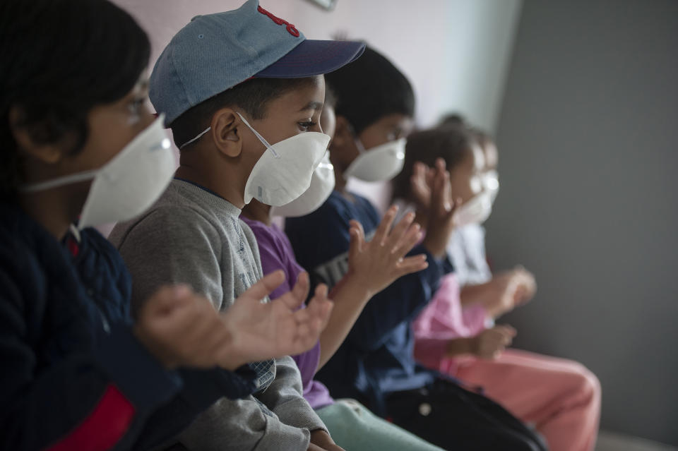 Learners wear masks as they sanitise their hans at a pre-school in Lenasia, Johannesburg, Tuesday, March 17, 2020, on the day schools closed in a bid to control the spread of coronavirus. For most people the virus causes only mild or moderate symptoms but for others is can cause more severe illness, especially in older adults and people with existing health problems. (AP Photo/Shiraaz Mohamed)